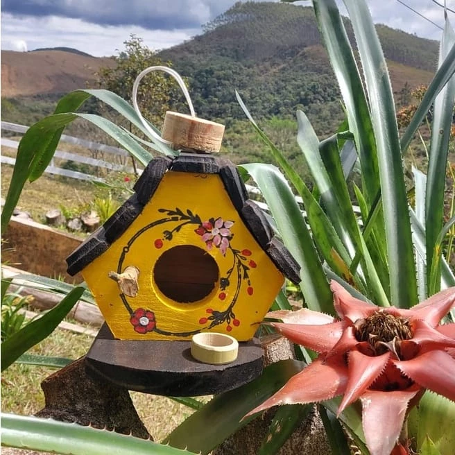 Casinha de passarinho com comedouro feita de madeira